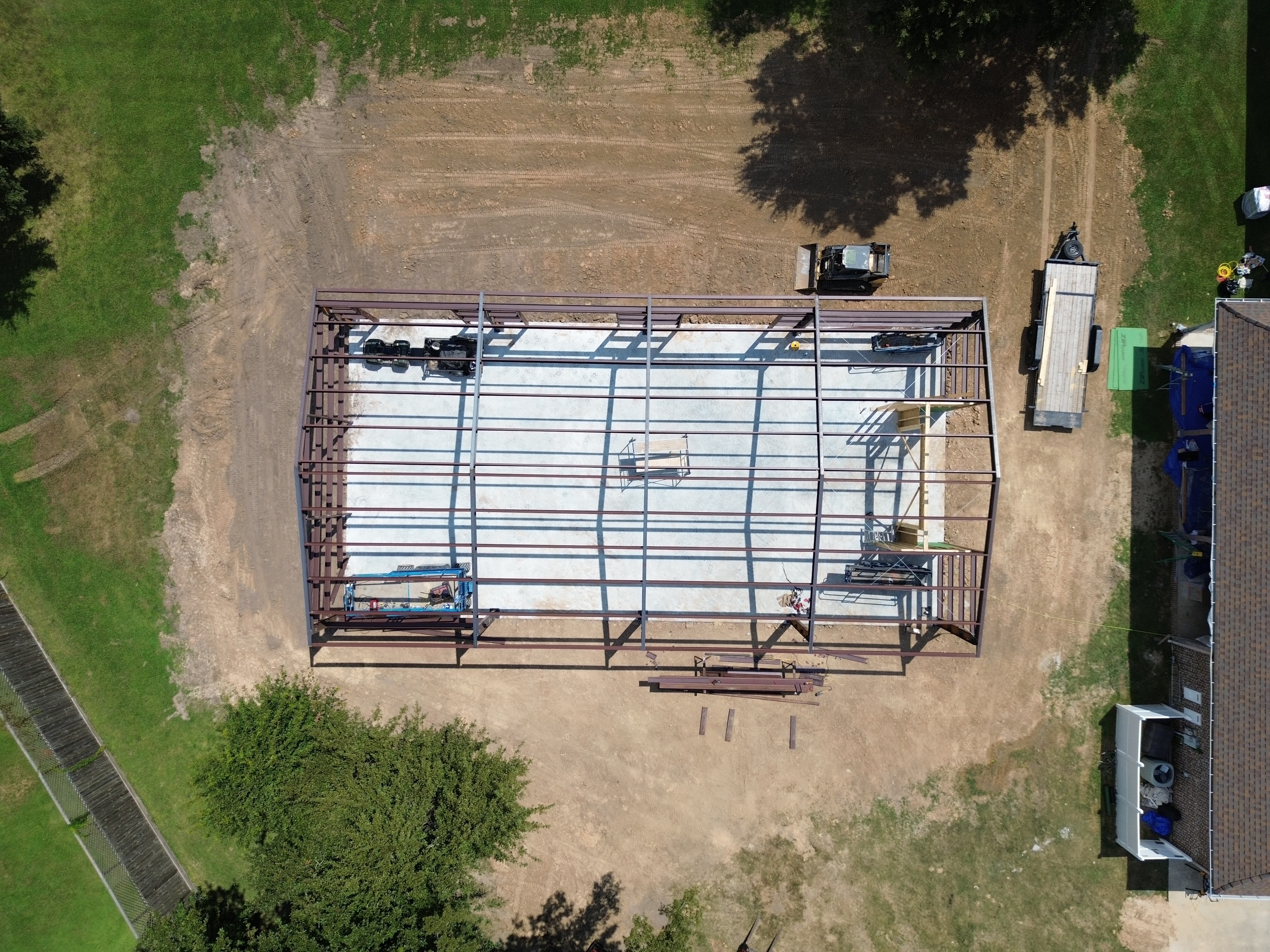 Aerial view of a steel building frame anchored to a finished concrete slab